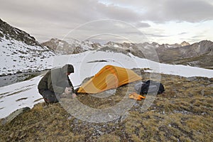 A man assembles a tunnel tent