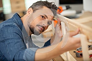 man assembling bed in new home photo