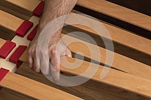 Man assembling bed slats close up.