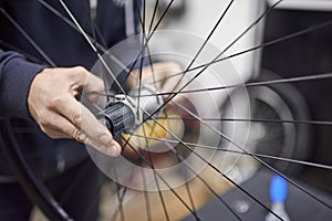 Man assembling a bike wheel axle after the process of cleaning and greasing