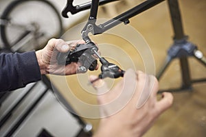 Man assembling the brake system of a bicycle as part of the maintenance service
