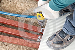 Man assembling composite deck using cordless screwdriver