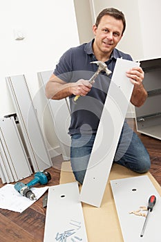 Man Assembling Flat Pack Furniture photo