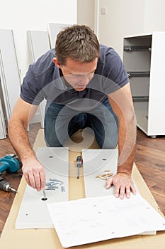 Man Assembling Flat Pack Furniture photo