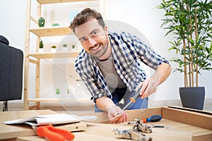 Man assembling furniture at home on the floor