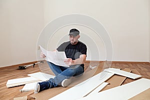 Man assembling furniture in new house. Carpenter repair and assembling furniture at home