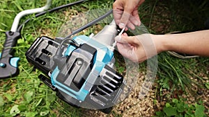 A man assembling parts of the string trimmer.