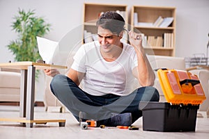 The man assembling shelf at home