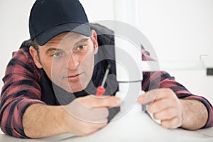 man assembling stool using screwdriver