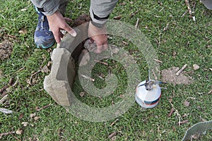 Man assembling a structure to stop the wind when cooking with his camp stove