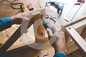Man assembly wooden furniture,fixing or repairing house with screwdriver tool.modern living concepts