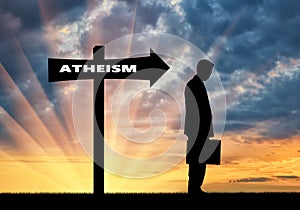 Man is an atheist in the direction where the sign shows atheism photo