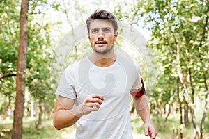 Man athlete with handband running outdoors in the morning