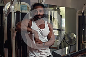 a man athlete Lankian with ruffled hair stands in the gym