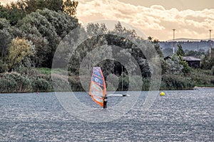 the man athlete rides the windsurf over the waves on lake