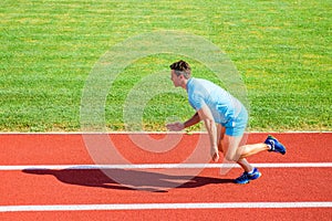 Man athlete runner push off starting position stadium path sunny day. Runner sprint race at stadium. Runner captured in