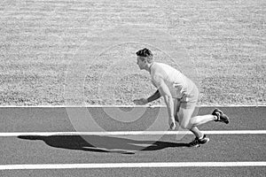 Man athlete runner push off starting position stadium path sunny day. Runner sprint race at stadium. Runner captured in