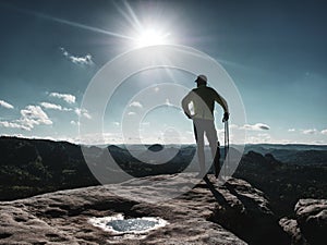 Man athlete runner with trekking poles running rocky trail