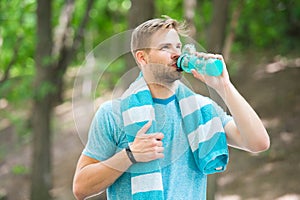 Man with athletic appearance holds bottle with water. Sport and healthy lifestyle concept. Athlete drink water after