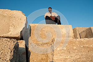 Man Atop Pile of Cement Blocks