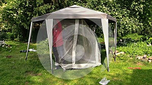 Man attach protective tent bower net in garden