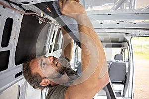 Man attaches thermal insulation on the inside of a van