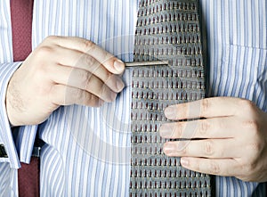 Man attaching tie clip to necktie