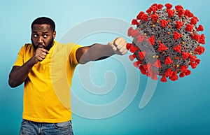 Man attacks with a punch the coronavirus. Blue background