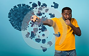 Man attacks with a punch the coronavirus. Blue background