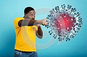 Man attacks with a punch the coronavirus. Blue background