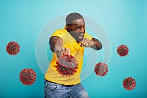 Man attacks with a punch the covid 19 coronavirus. Blue background