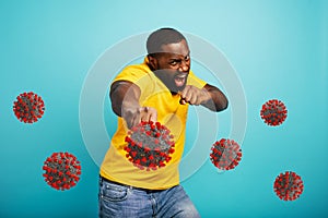 Man attacks with a punch the covid 19 coronavirus. Blue background photo