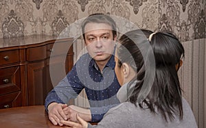 A man attentively listens to a woman sitting at a Desk in the office. Concept, psychological help, problem solving training, famil