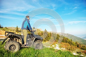 Man on the ATV Quad Bike on the mountains road.