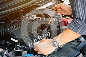 Man or auto mechanic worker hands checking the car engine oil and maintenance. photo