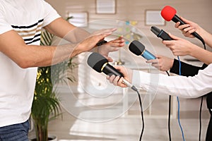 Man avoiding journalist`s questions at interview indoors