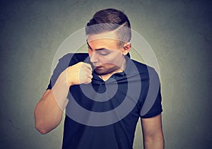 Man in awkward situation opening shirt to vent isolated on gray background. Human emotions facial expression