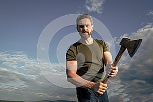 man with axe. craftsman man hold ax. brutal man on sky background