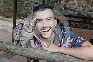 Man with baby serval cat