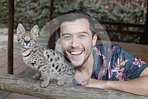 Man with baby serval cat