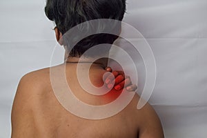 Man from back having red spot of pain and feeling exhausted and suffering from neck pain