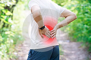 Man with back pain, injury while running, trauma during workout