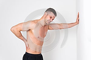 A man back pain keeps his hand on his back ache hurt injury, ill caucasian health medical, muscular holding. Tension