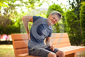 Man with back pain outdoor. Healthcare and medicine concept