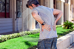 Man with back pain at the street. People, health care and medicine concept