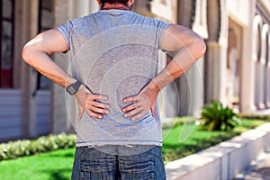 Man with back pain at the street. People, health care and medicine concept