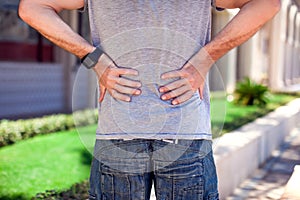 Man with back pain at the street. People, health care and medicine concept