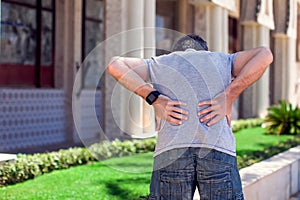Man with back pain at the street. People, health care and medicine concept