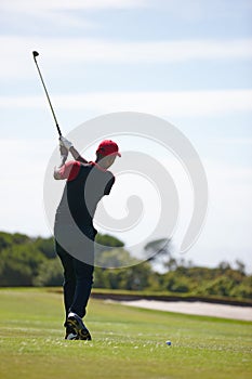 Man, back and swing with golf course for stroke, point or strike on grass field in nature. Rear view of male person