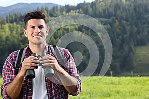 Man with backpack and binoculars in mountains